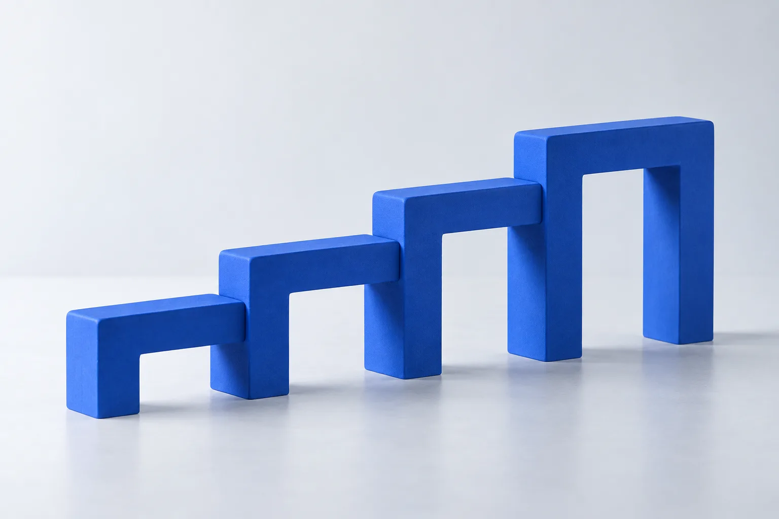 Decorative brand artwork: ascending cobalt blocks linked in a row on a light surface.